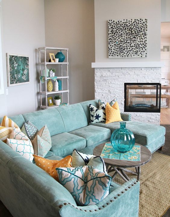 a neutral room is spruced up with a gorgeous aqua sectional sofa and accessories