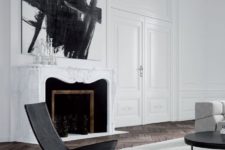 08 a white marble-clad fireplace with black inside and some figures for an artistic feel