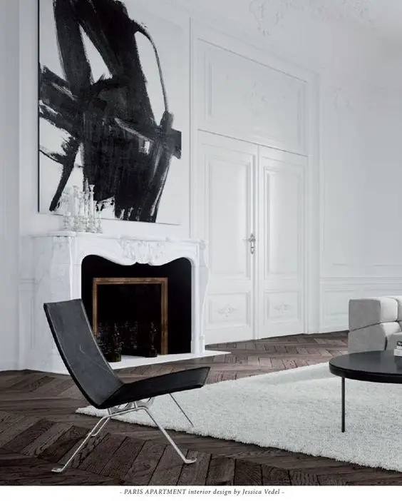 a white marble-clad fireplace with black inside and some figures for an artistic feel