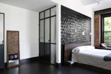 09 The master bedroom features a black tile statement wall and exposed brick