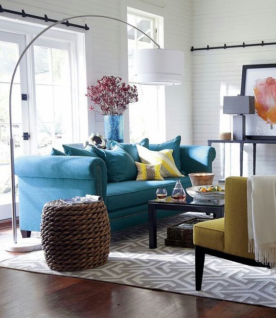 a bold blue sofa and a sunny yellow chair and pillows for a gorgeous coastal room