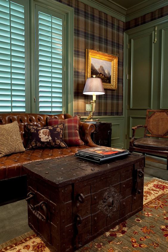 A dark colored vintage chest as a coffee table for a traditional and masculine living room