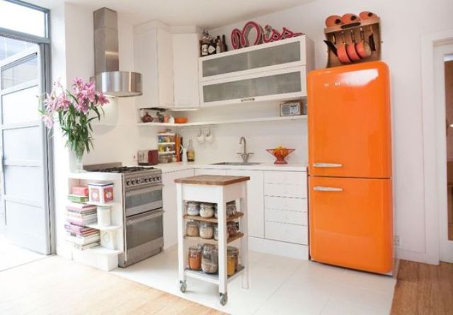 a neutral modern kitchen with a bold orange Smeg fridge for a colorful statement