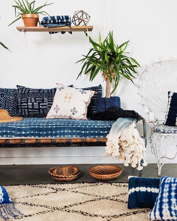 shibori pillows and an upholstered bench add to the look of this boho inspired space