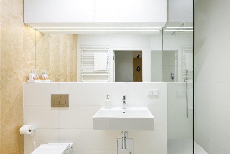 The bathroom is small and done in white and the same wood as everywhere, to connect the space