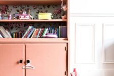 10 a coral-colored sideboard with shelves and floral wallpaper inside for a kids’ room