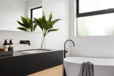 10 large matte black rectangular tiles on the floor and matching ones in white on the wall create a real home spa
