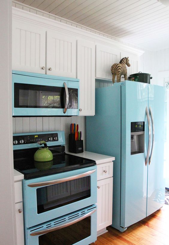 a blue fridge, microwave and cooker spruce up the traditional white kitchen