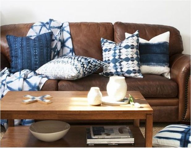 A brown leather sofa looks refreshed and more eye catchy with shibori pillows and a blanket