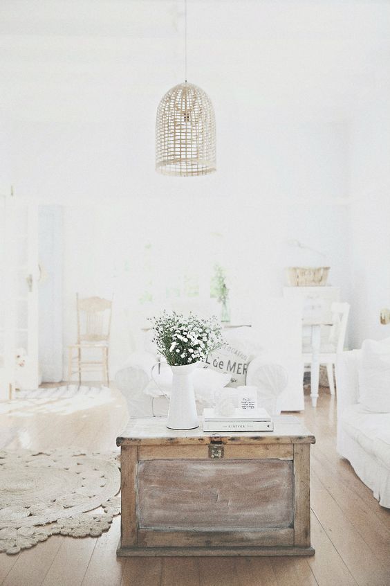 A shabby chic neutral room with a wooden chest as a coffee table   wood texture adds coziness