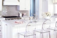 11 an all-white kithen is spruced up with a glossy beige kitchen backsplash and acrylic chairs