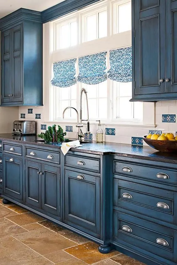 blue chalkboard painted cabinets with a vintage design and printed Roman shades