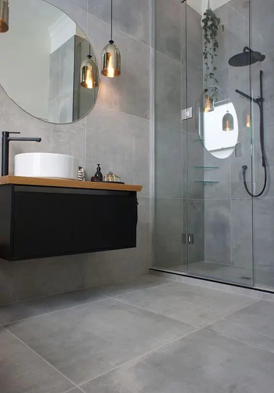 concrete-looking matte grey tiles cover the whole bathroom and make it modern and refined