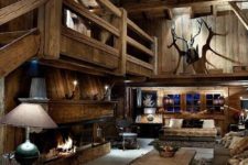 11 cozy rustic man cave with lots of wood, antlers, a fireplace and taxidermy