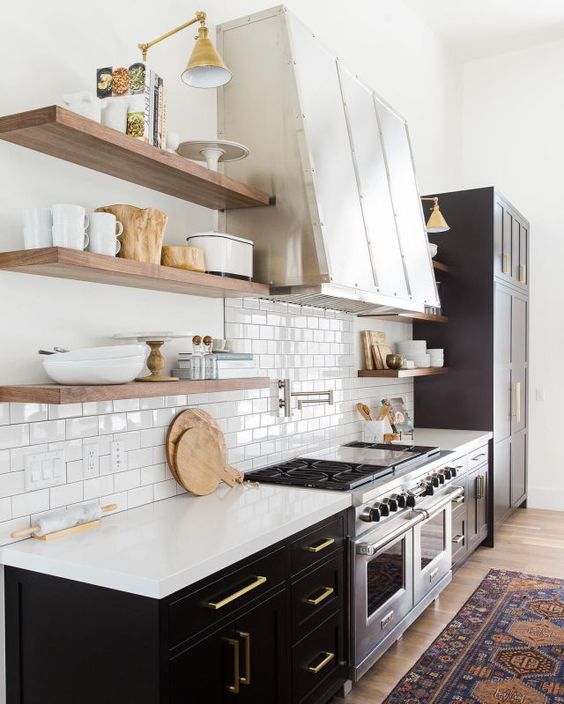 Retro inspired black and white kitchen with brass touches, nautral wood and a glossy white backsplash