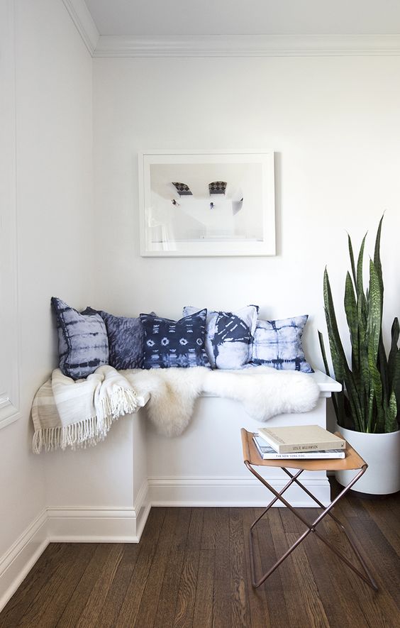 a cozy reading nook is spruced up with shibori pillows and a faux fur cover
