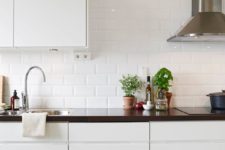 13 glossy white subway tile add interest and shine to a modern sleek kitchen
