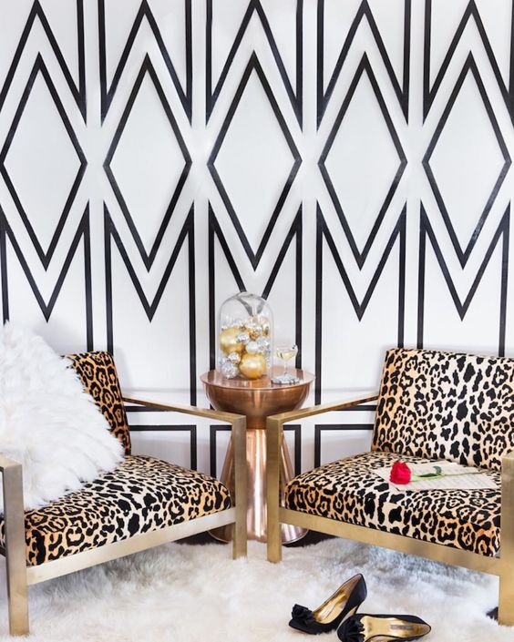statement geo wallpaper wall and brass cheetah print chairs, a faux fur gur make this nook very glam