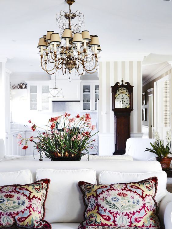 A modern space is made more eye catchy with a vintage inspired chandelier and a vintage clock