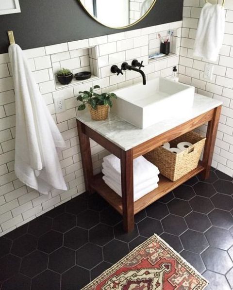 matte black hex tiles on the floor and matte white subway tiles with black grout for an elegant bathroom