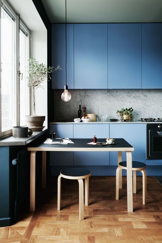 muted blue modern kitchen with a marble backsplash and sleek cabinets