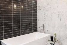 15 white marble, glossy black tiles and a geometric bathtub make this minimalist space really stand out