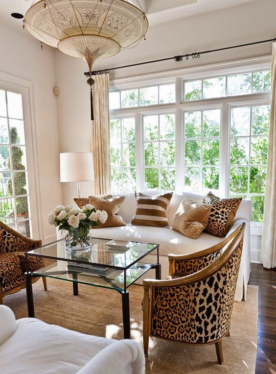 cheetah print upholstered chairs and pillows add eye-catchiness to a neutral living room