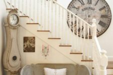 17 a French farmhouse hallway with a vintage clock and a cute loveseat