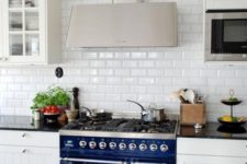 18 a traditional white kitchen is made eye-catchy with a subway tile backsplash and a cobalt blue cooker