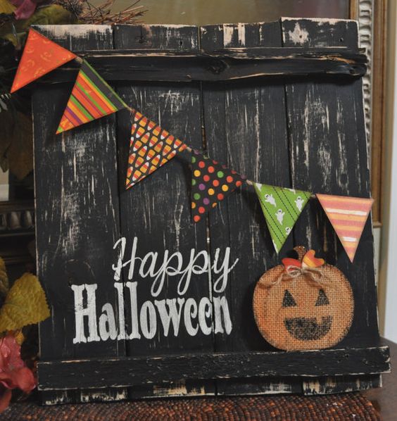 a black shabby rustic sign with a colorful banner, a burlap pumpkin applique and Happy Halloween words
