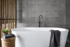 21 matte grey large scale tiles and natural wood make up a chic home spa