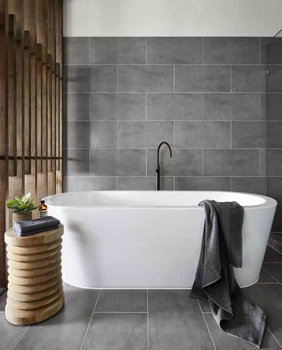 matte grey large scale tiles and natural wood make up a chic home spa