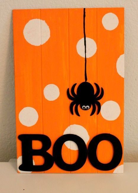 a bold orange and white polka dot sign with a spider applique and BOO letters