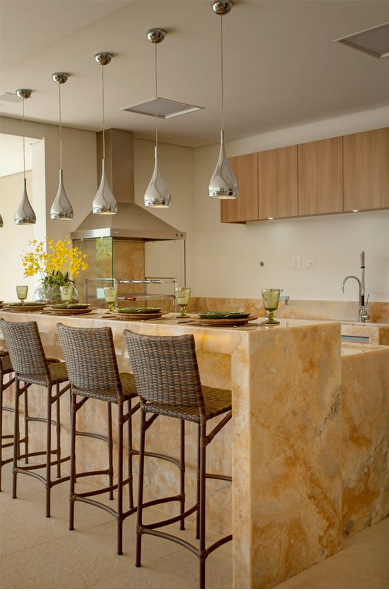A gorgeous two level kitchen island with a countertop for having meals made of marble