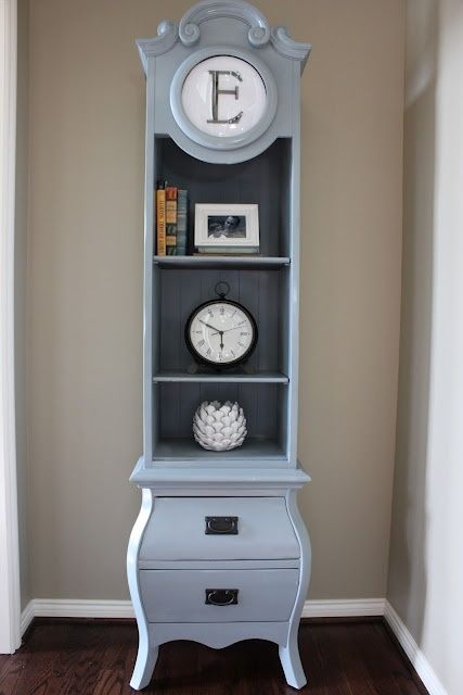 a grandfather's clock was repainted and repurposed into a shelf with drawers