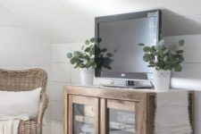 23 a farmhouse glass sideboard with blankets and a TV on it