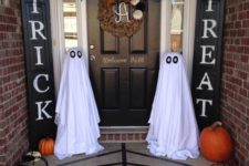 23 ghosts of white sheets are placed on both sides of the entrance