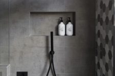 23 matte grey tiles in the shower and hex shaped ones in grey shades for an accent wall