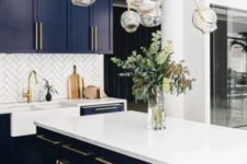 23 very dark blue kitchen cabinets with white countertops and white herringbone tiles