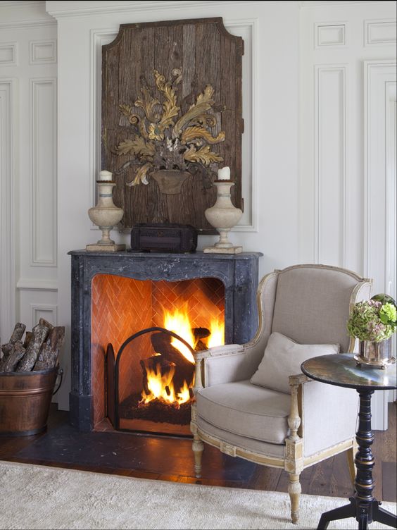 a vintage fireplace is used to make the living room cozier and is styled with a large wooden artwork