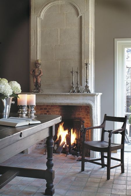 a vintage stone clad fireplace with brick inside adds a cozy feel to the dining space