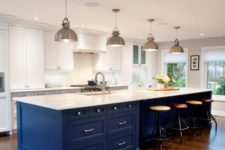 25 a white kitchen is spurced up with a large bold blue island, which is topped in white to connect to the space