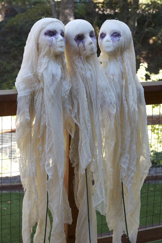 Scary cheesecloth ghosts with human like faces decorated with ink are great for outdoors