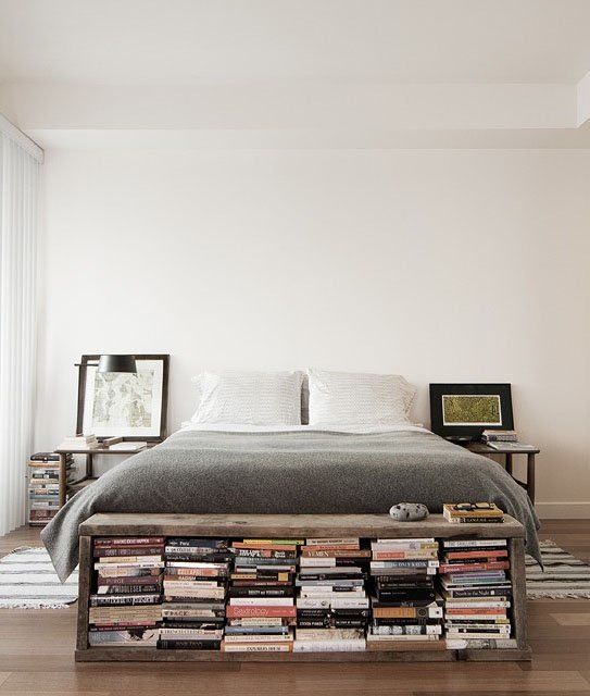 A storage bench at the foot of the bed filled with books is a cool space saving idea