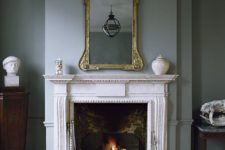 27 an antique fireplace with a metal construction is really used, white marble saves the wooden floors