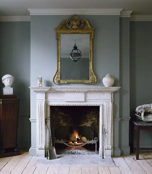an antique fireplace with a metal construction is really used, white marble saves the wooden floors