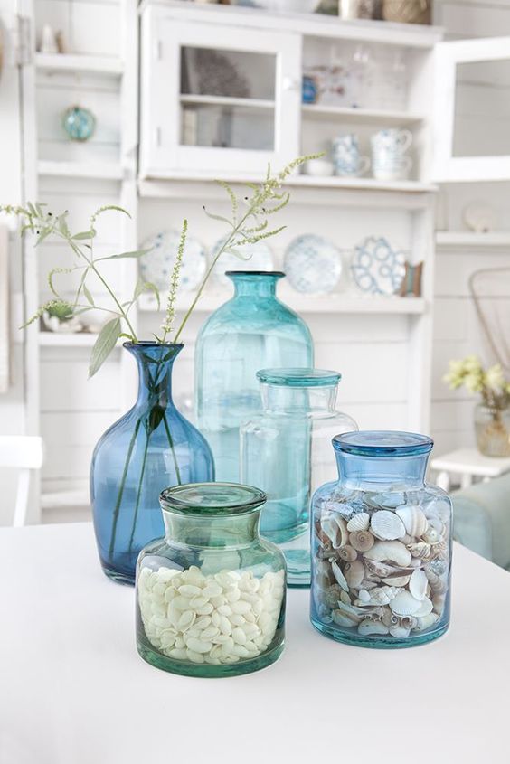 aqua, blue and turquoise glass bottles with shells and herbs for a Mediterranean arrangement