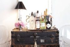 28 a large black vintage chest is used as a home bar, and everything necessary is inside it