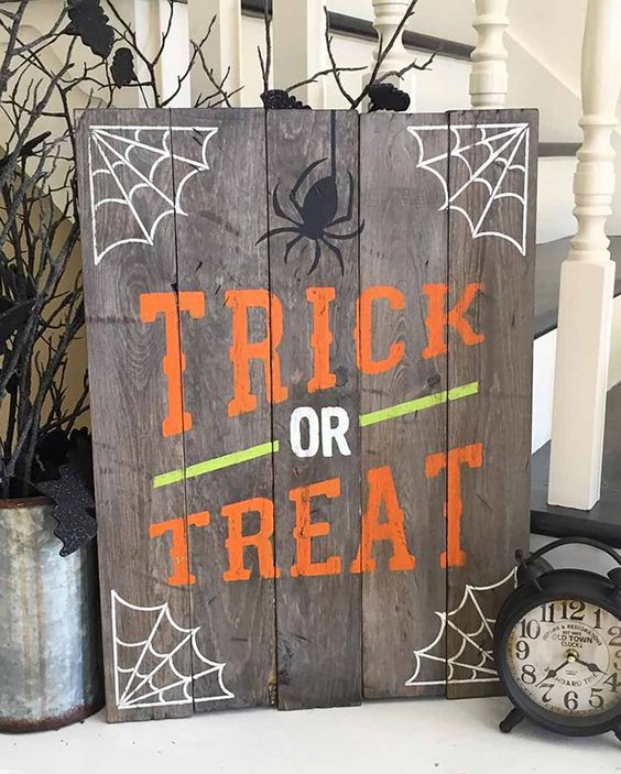 a simple pallet Trick Or Treat sign with webs, spiders and in bold colors