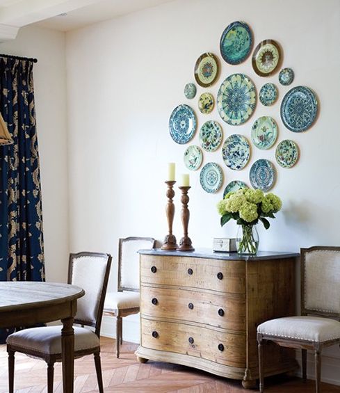 blue and green decorative plates styled on the wall of a dining room